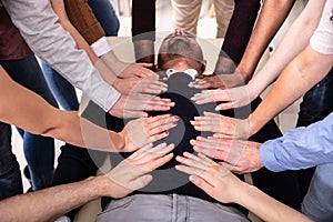 Group Of Hands Touching Man`s Body Lying On Table