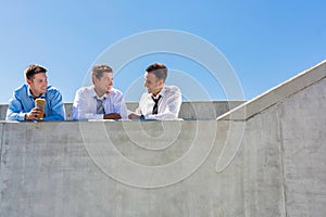 Group of handsome businessmen discussing plans in office rooftop during break