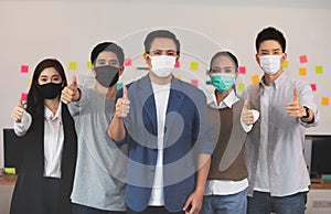 Group of Happy Asian business men leader standing making thumbs up with Business team at Co-Working space fight due COVID-19 virus