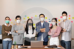 Group of Happy Asian business men leader standing wearing mask smile cross arm confidence with Business team at Co-Working space