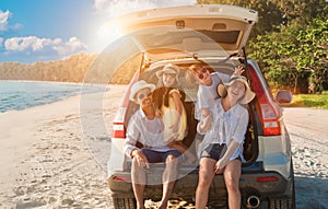 Group of happy Asian family fun travel on road trip in vacation at beach. Father, mother, daughter, son with enjoying on hatchback