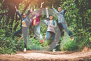 Group of happy Asian teenage adventure traveler trekkers group jumping together in mountain at outdoor forest background. Young