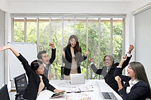 Group of happy business people cheering in office. Celebrate success. Business team celebrate a good job in the office. Asian