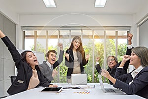 Group of happy business people cheering in office. Celebrate success. Business team celebrate a good job in the office. Asian