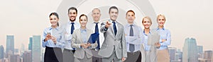 Group of happy business people pointing at you