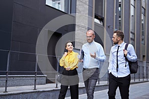 Group of happy business people walking in front of the office
