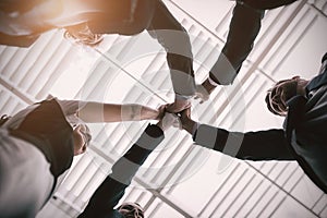 Group of happy businesspeople giving high five to each other