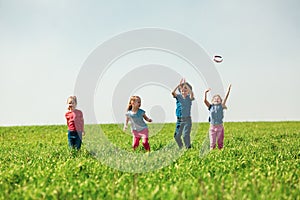A group of happy children of boys and girls run in the Park on the grass on a Sunny summer day . The concept of ethnic friendship