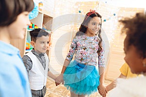 Group of happy children dancing round dance on birthday party. Concept of children`s holiday.