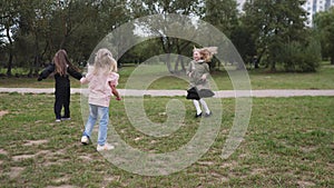 group of happy children girls playing rejoicing in spring or summer park