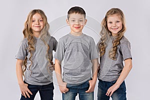 Group of happy children in gray t-shirts isolated on white background