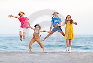 Group of happy children jump by   sea in summer