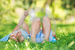 Group of happy children lying on green grass