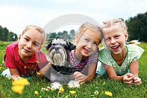 Group of happy children playing on green grass in spring park