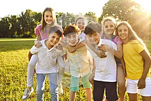 Group of happy children playing and having fun in a green sunny park in the summer