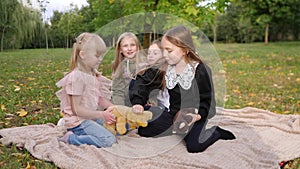 Group of happy children playing in the park together on the grass