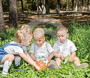 Group of happy children playing with soccer ball in park on nature at summer.