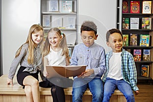 Group happy children reading book in classroom. Back to school. Study and education concept