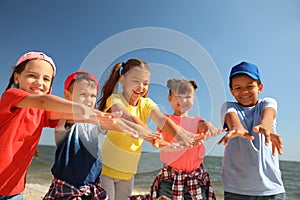 Group of happy children at sea beach on sunny day. Summer camp