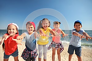 Group of happy children at sea beach on sunny day. Summer camp