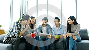 Group of happy creative team discussing while taking coffee break at office