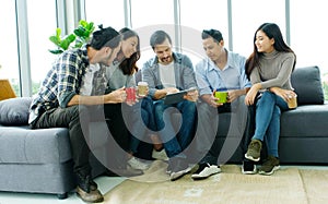 Group of happy creative team discussing while taking coffee break at office