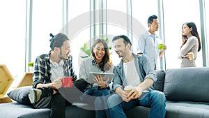 Group of happy creative team discussinng while taking coffee break at office