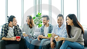 Group of happy creative team talking while taking coffee break at office