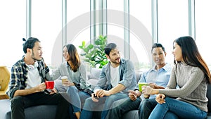 Group of happy creative team talking while taking coffee break at office