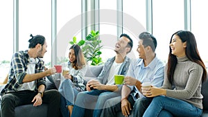 Group of happy creative team talking while taking coffee break at office