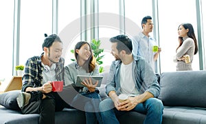 Group of happy creative team talking while taking coffee break at office