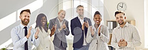 Group of happy diverse business people looking at the camera, smiling and applauding.