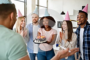 Group of happy diverse friends having birthday celebration, congratulating their fellow student, enjoying party at home