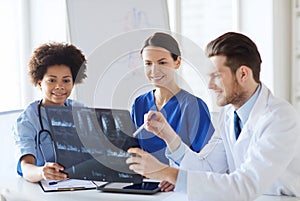 Group of happy doctors discussing x-ray image