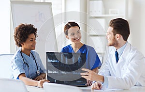 Group of happy doctors discussing x-ray image