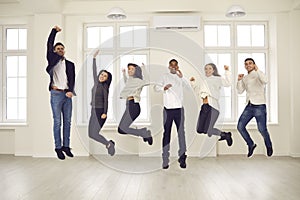 Group of happy energetic colleagues or friends jumping all together and celebrating success