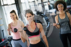 Group of happy multiracial friends exercising together in gym