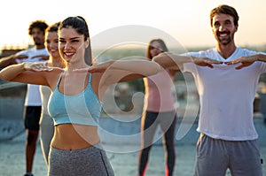 Group of happy fit friends exercising together outdoors. Sport people healthy lifestyle concept