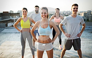 Group of happy fit young people friends in sportswear doing exercises . Sport outdoors