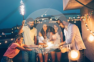 Group of happy friends celebrating at rooftop