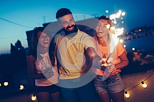 Group of happy friends celebrating at rooftop