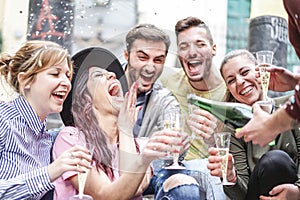 Group of happy friends doing party throwing confetti and drinking champagne outdoor - Young people having fun celebrating birthday