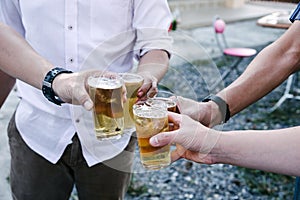 Group of happy friends drinking and toasting beer at bbq party asian person
