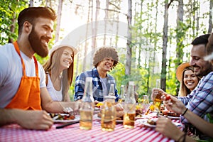 Group of happy friends eating and toasting at garden barbecue