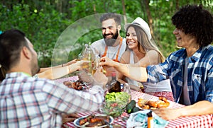 Group of happy friends eating and toasting at garden barbecue