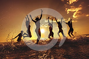 Group of happy friends fun sunset beach