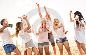 Group of happy friends having fun at beach party on holi colors