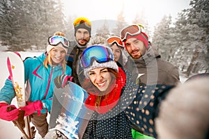 Group of happy friends having fun Snowboarders and skiers making photo