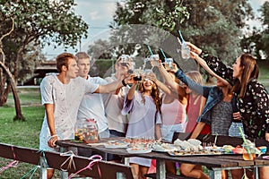 Group of happy friends having fun together celebrating a birthday at the outdoor park. Joyful friends cheering with