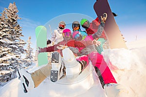 Group of happy friends having fun in winter forest. Snowbarders and skiers group team friendship ski resort sun light